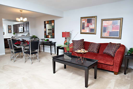 a living room with a red couch and a dining room table