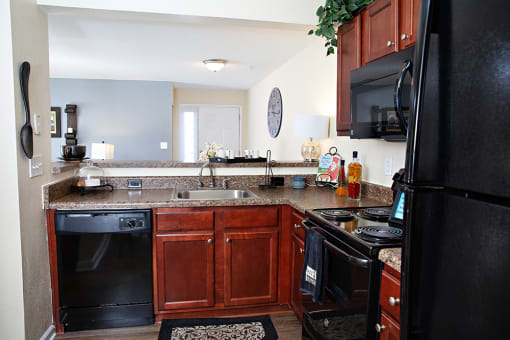 a kitchen with brown cabinets and black appliances