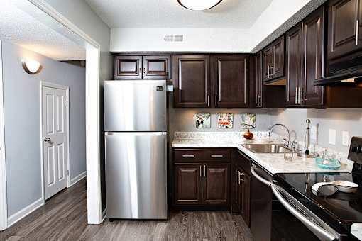 kitchen with dark cabinets and stainless steel appliances at The Mews in Durham NC