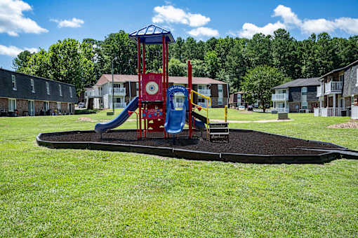 A playground with a red and blue slide and a blue and yellow structure.