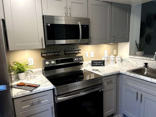 A kitchen with a black oven and a black microwave.
