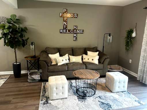 A living room with a couch, a table, and a plant.