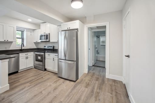 a renovated kitchen with stainless steel appliances and white cabinets