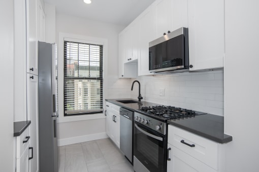 a white kitchen with a stove and a microwave