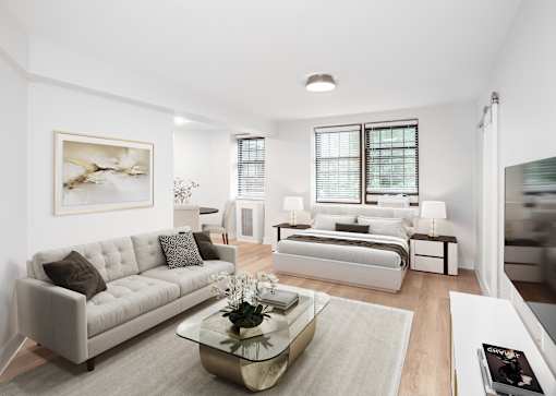 A modern living room with a white couch and a coffee table in the center.