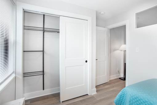 a bedroom with a bed and a closet with white doors