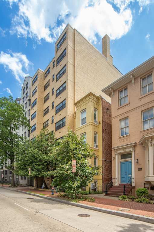 an apartment building with a blue door on a street