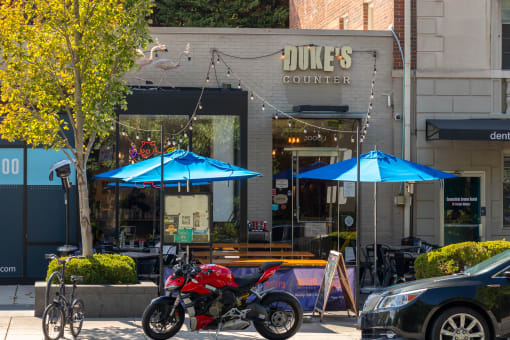 a motorcycle parked in front of a dukes counter on a city street
