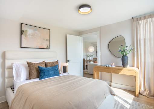 A bedroom with a large bed and a mirror on the wall.