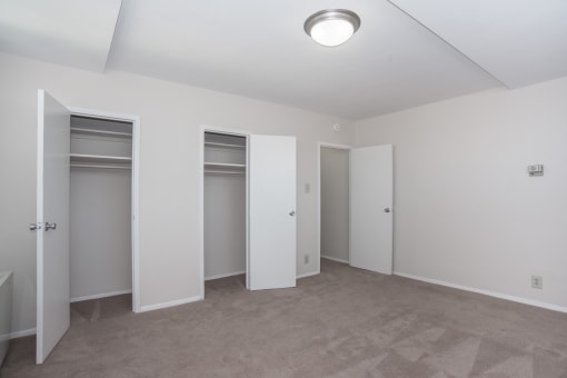 a room with three closets and a carpeted floor and white walls