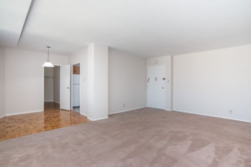 an empty living room with white walls and a beige carpet