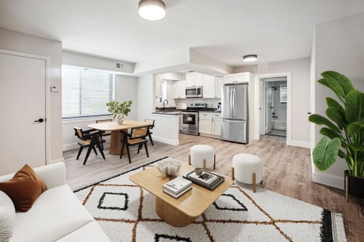 a living room and kitchen with white walls and wood flooring