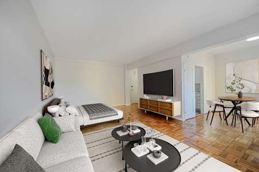 A modern living room with a grey sofa, a black coffee table, and a television.