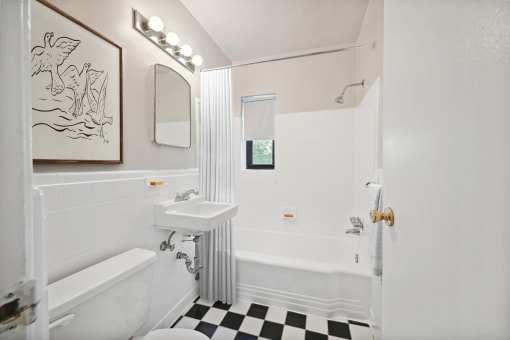 a white bathroom with a black and white checkered floor