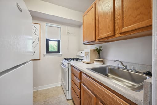 a kitchen with white appliances and wooden cabinets and a sink