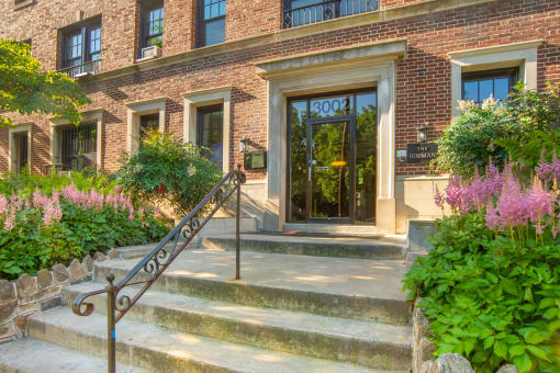 the front of a brick building with stairs and a glass door