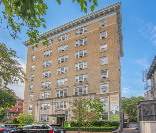 a tall brick building with many windows and a street in front