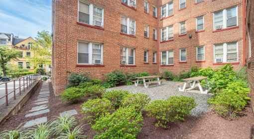 the courtyard of a brick building with a picnic table and benches