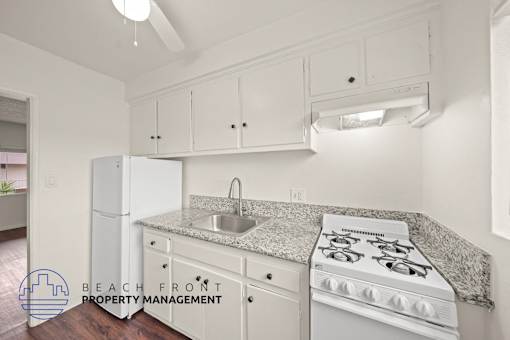 A kitchen with white appliances and cabinets.
