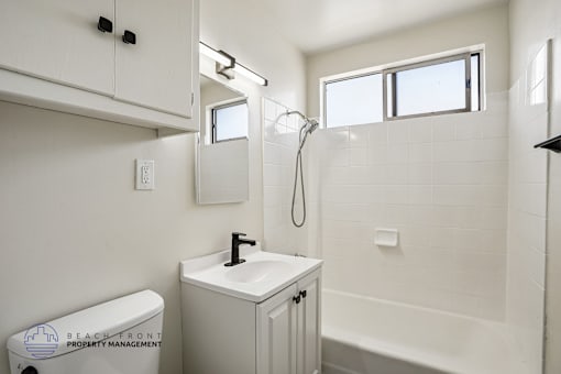 A white bathroom with a toilet, sink, and bathtub.