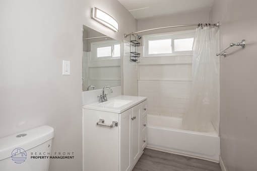 A white bathroom with a toilet, sink, and bathtub.