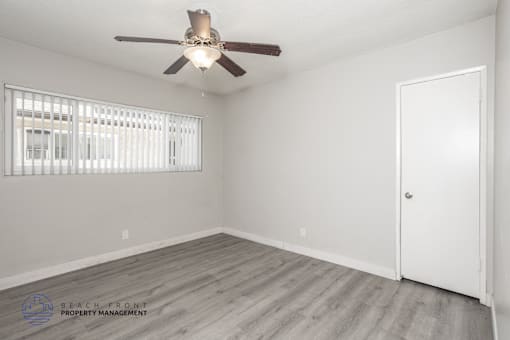 A room with a ceiling fan and a door.