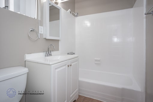 A white bathroom with a toilet, sink, and bathtub.