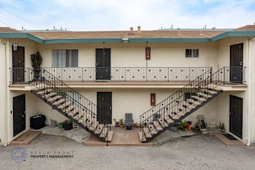 A two-story building with a balcony and stairs leading to the second floor.