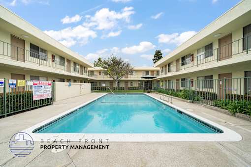 A pool in a courtyard surrounded by buildings.