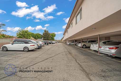 A parking lot with cars and a building in the background.