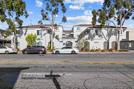 A street view with cars and apartment buildings.