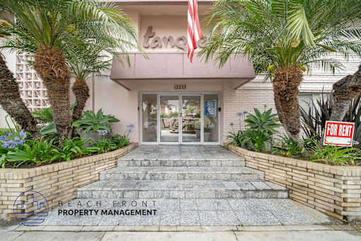 The front of a building with a "For Rent" sign in front of it.