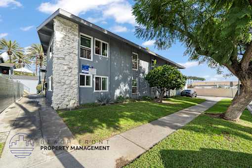 A building with a stone pillar and a sign that says "BEACH FRONT PROPERTY MANAGEMENT".