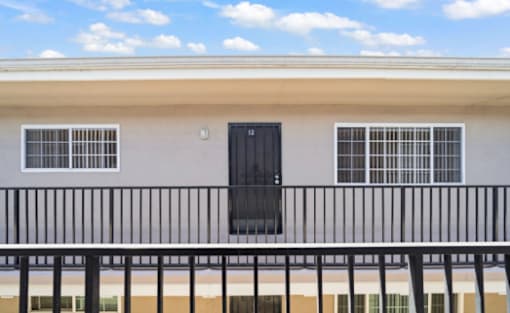 A building with a black door and windows with white bars.
