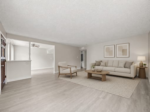 A living room with a white couch, a wooden coffee table, and a rug.