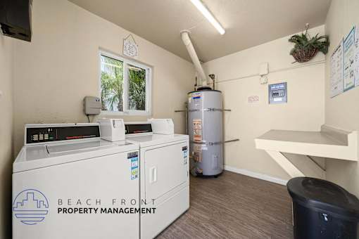 A room with a washing machine, dryer, and a water heater.