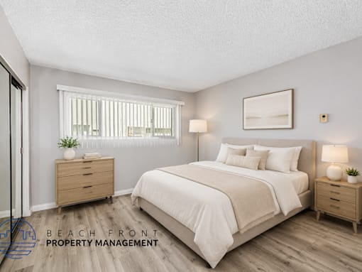 A bedroom with a large bed, two nightstands, and a window with blinds.