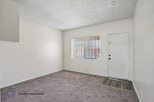 A room with a carpeted floor and a door.