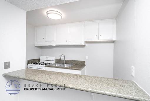 an interior view of a kitchen with white cabinets and a counter top