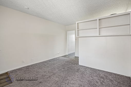 A room with a grey carpet and white walls.