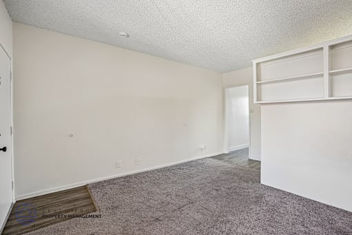 A room with a carpeted floor and white walls.