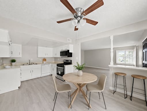 A kitchen with a table and chairs.