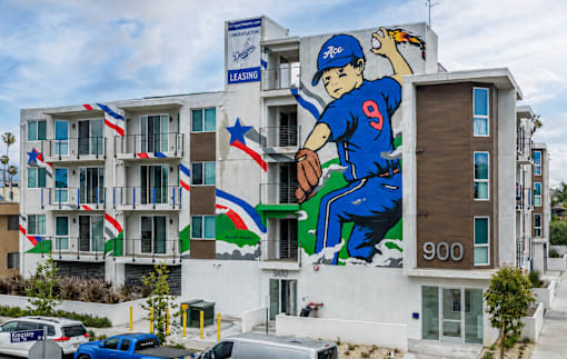 A large mural of a baseball player in blue jersey number 9 is painted on the side of a building.