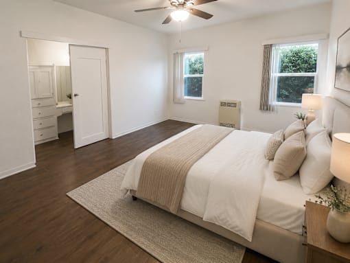 A bedroom with a bed, dresser, and window.