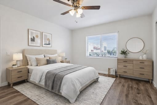 A bedroom with a bed, dresser, and window.