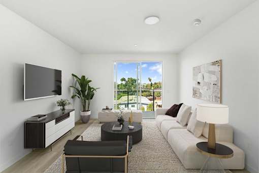 A modern living room with a large window and a flat screen TV mounted on the wall.