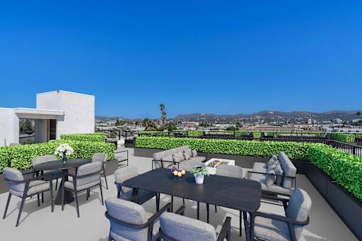 A patio with a table and chairs overlooking a mountainous landscape.
