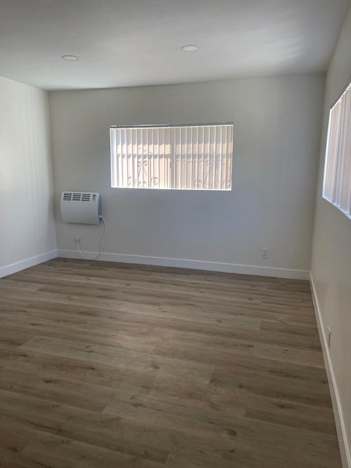 living room with a window and a wooden wall
