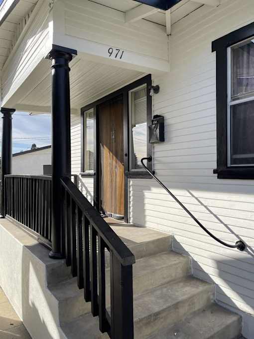the front of a house with stairs and a door