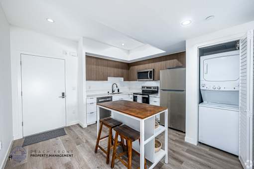 A kitchen with a wooden table and bar stools.